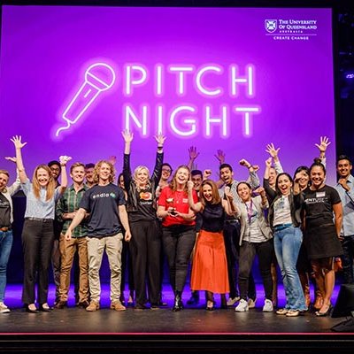 Group shot of Pitch Night finalists on stage with Ashley Hanger, the winner, in the middle holding the trophy